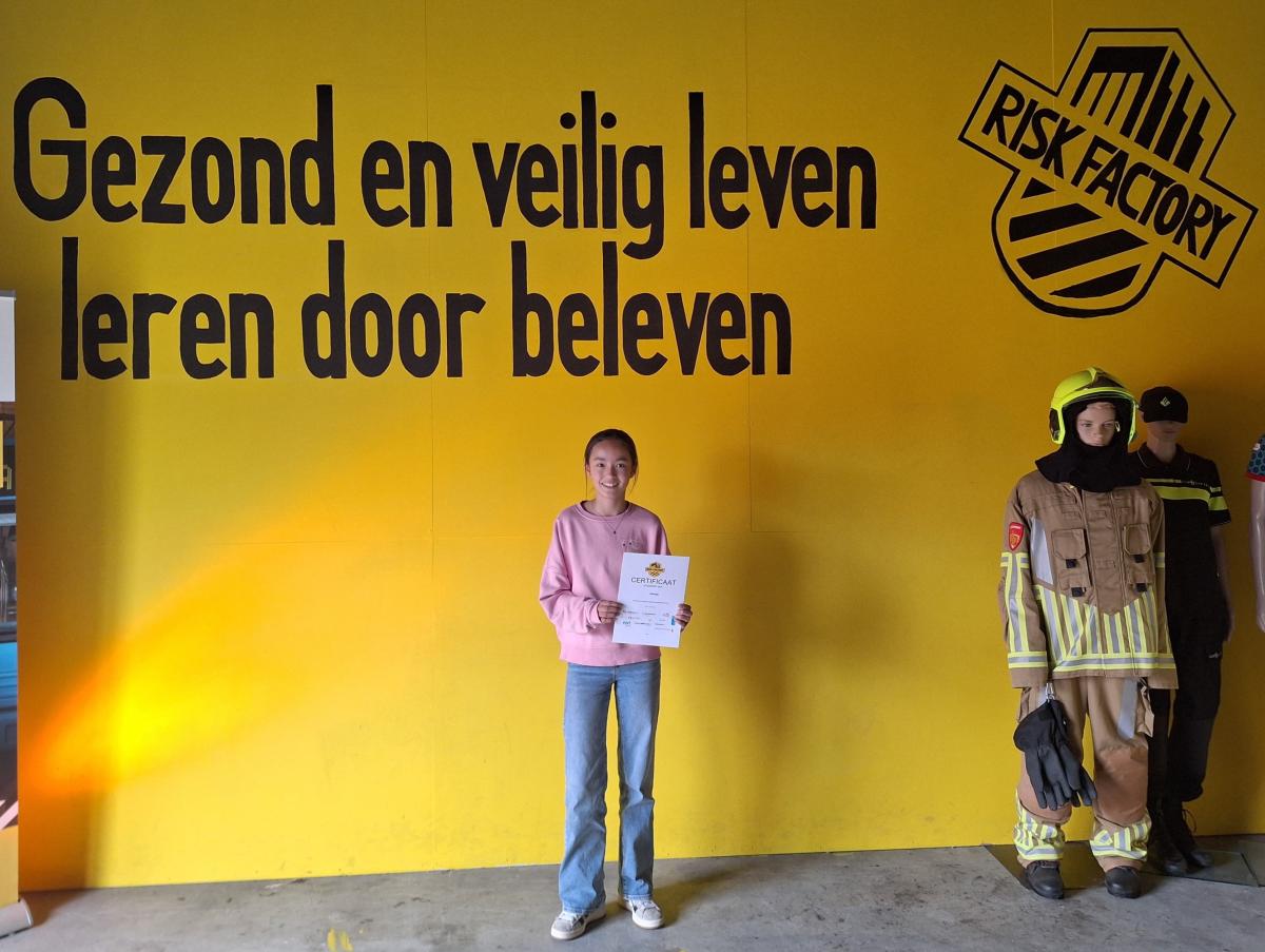 Jasmijn is de 15.000e leerling van de Risk Factory. Ze staat op de foto met haar certificaat. 