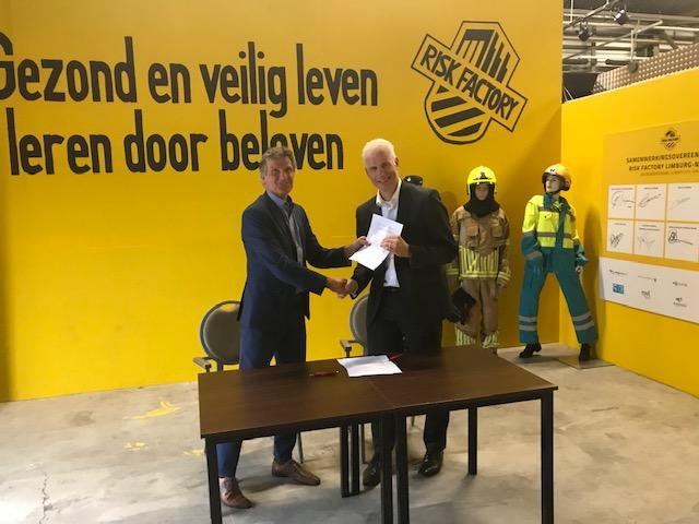 Directeur Rabobank Venlo e.o. Addy Lutgenau en directeur Veiligheidsregio Limburg-Noord Jac Rooijmans ondertekenen samenwerkingsovereenkomst en staan met overeenkomst in de hand