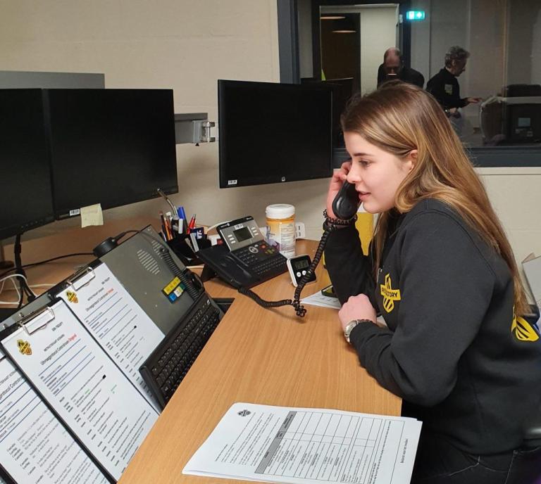 Stagiaire Isa is aan het bellen met een vaste telefoon