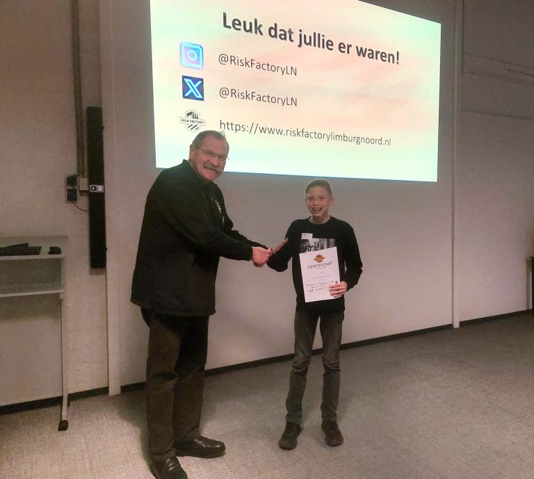 10.000e leerling Lars ontvangt het certificaat van een begeleider